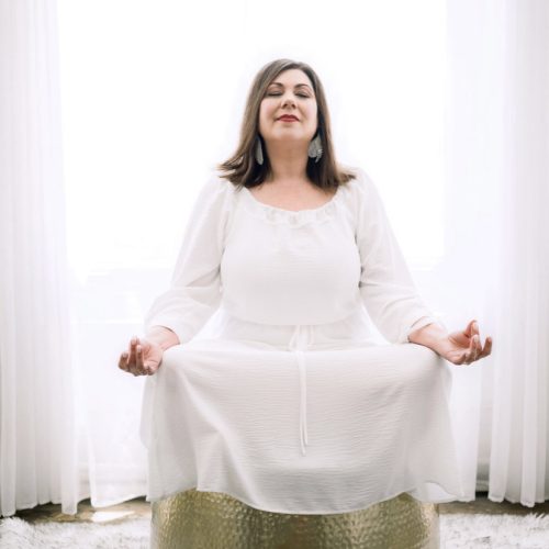 Aileen Nealie in white dress meditating