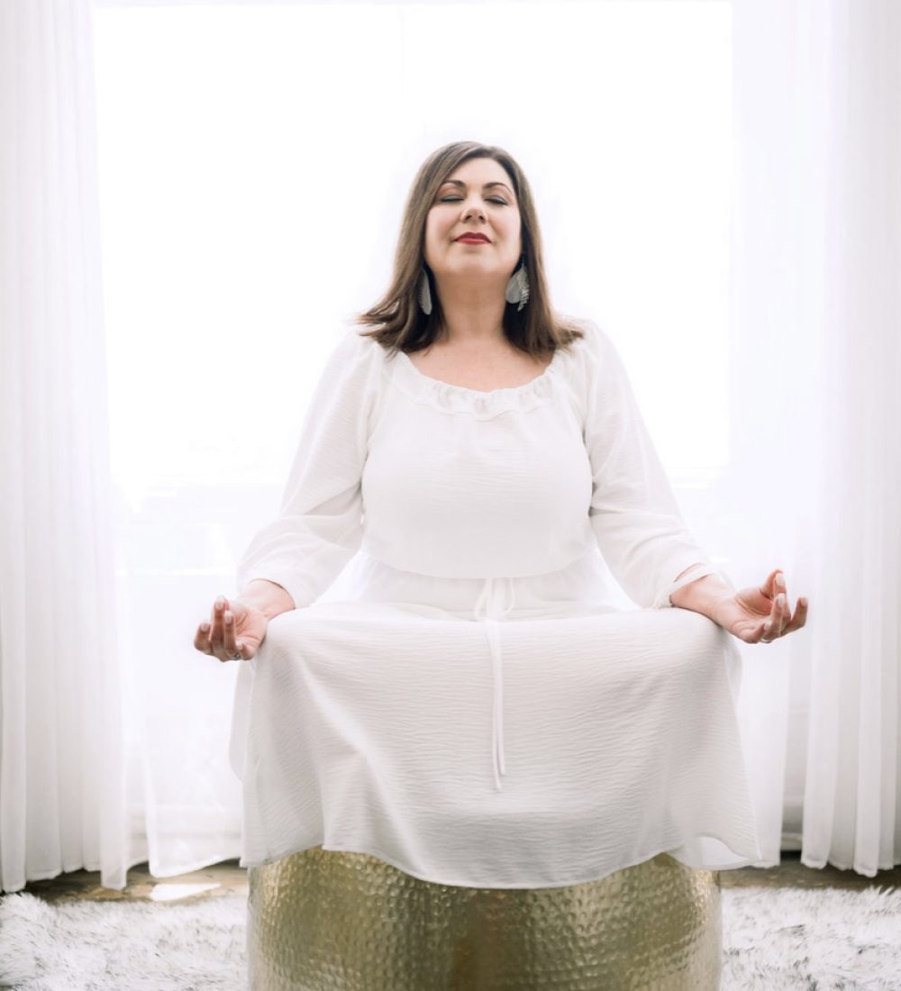 Aileen Nealie in white dress meditating